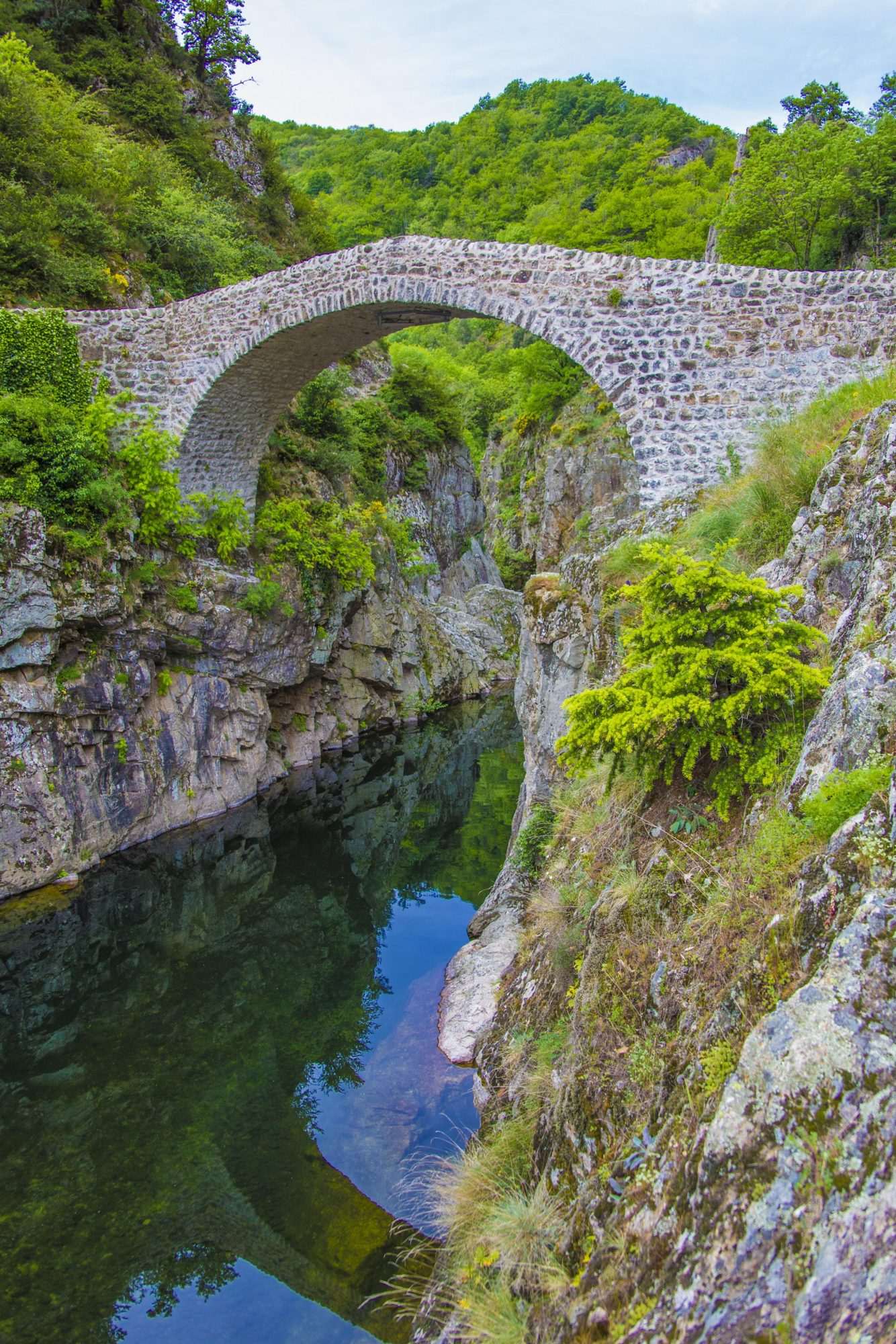 Natuurstenen Boogbrug boven Turquoise Rivier